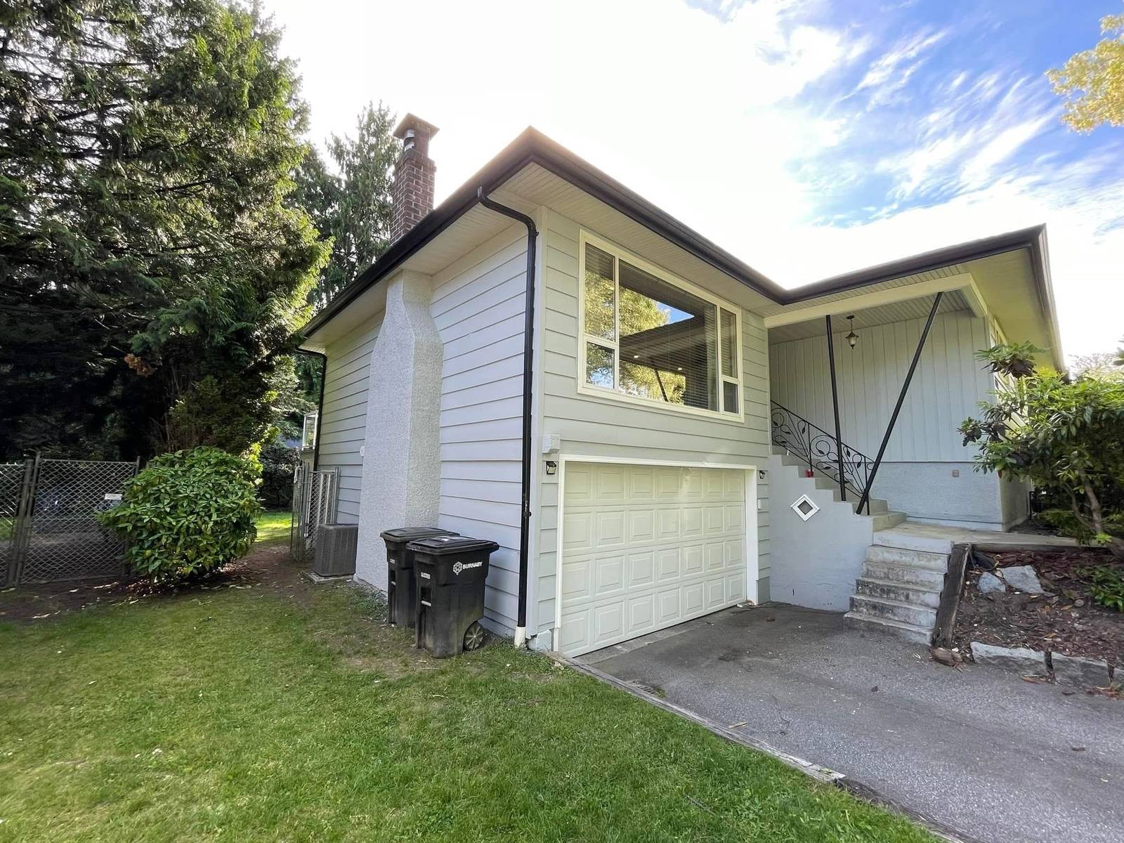 Side of a house with fresh exterior paint and a double garage