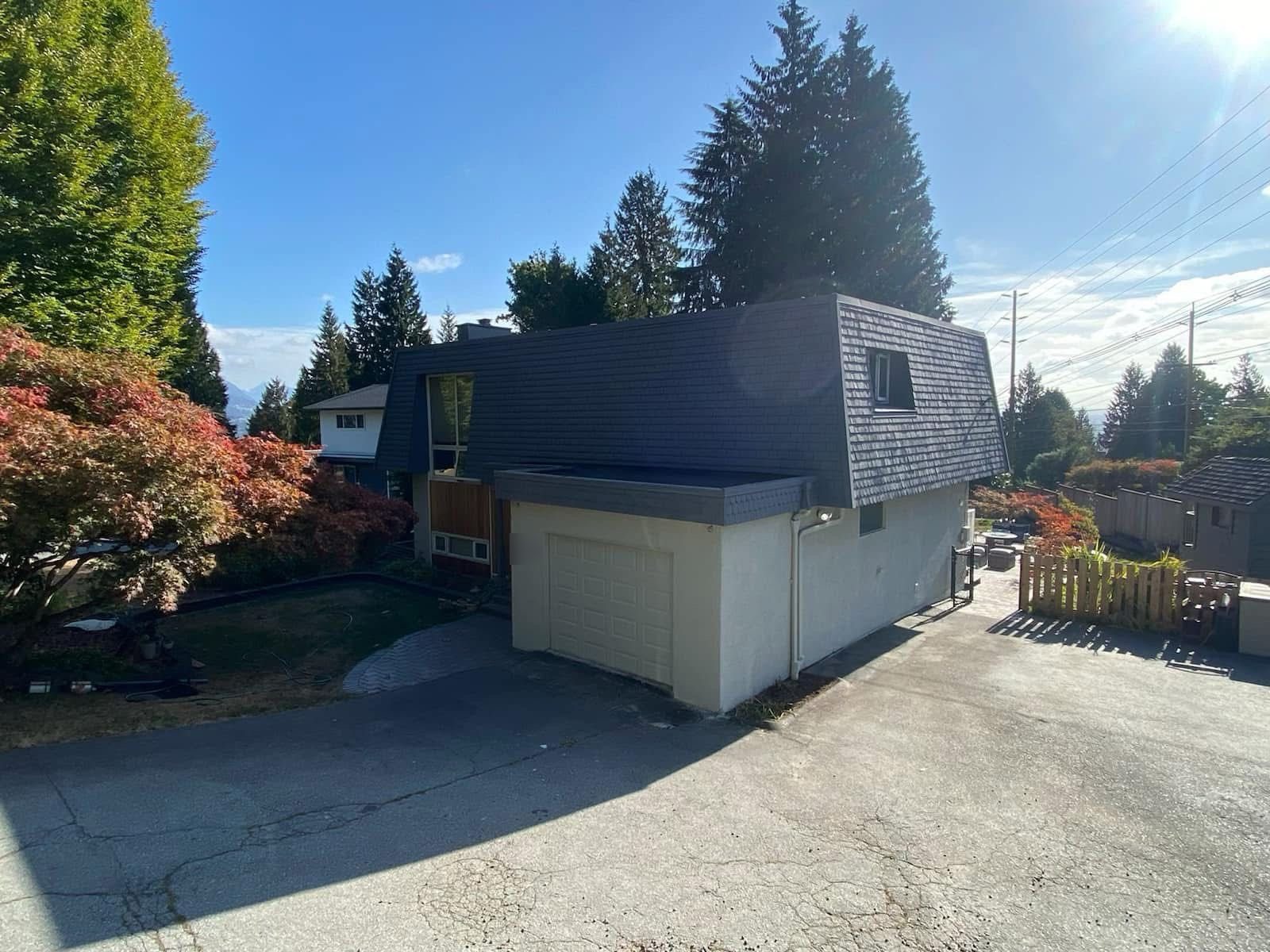 Home exterior with a white stucco garage, dark roof and mountains in the background