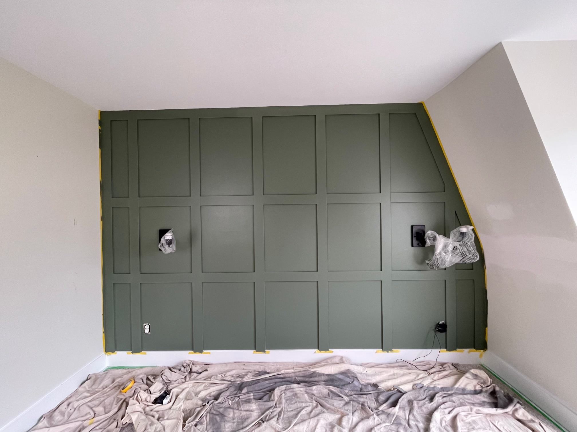 Dark green panelled feature wall in an interior room, masked for painting