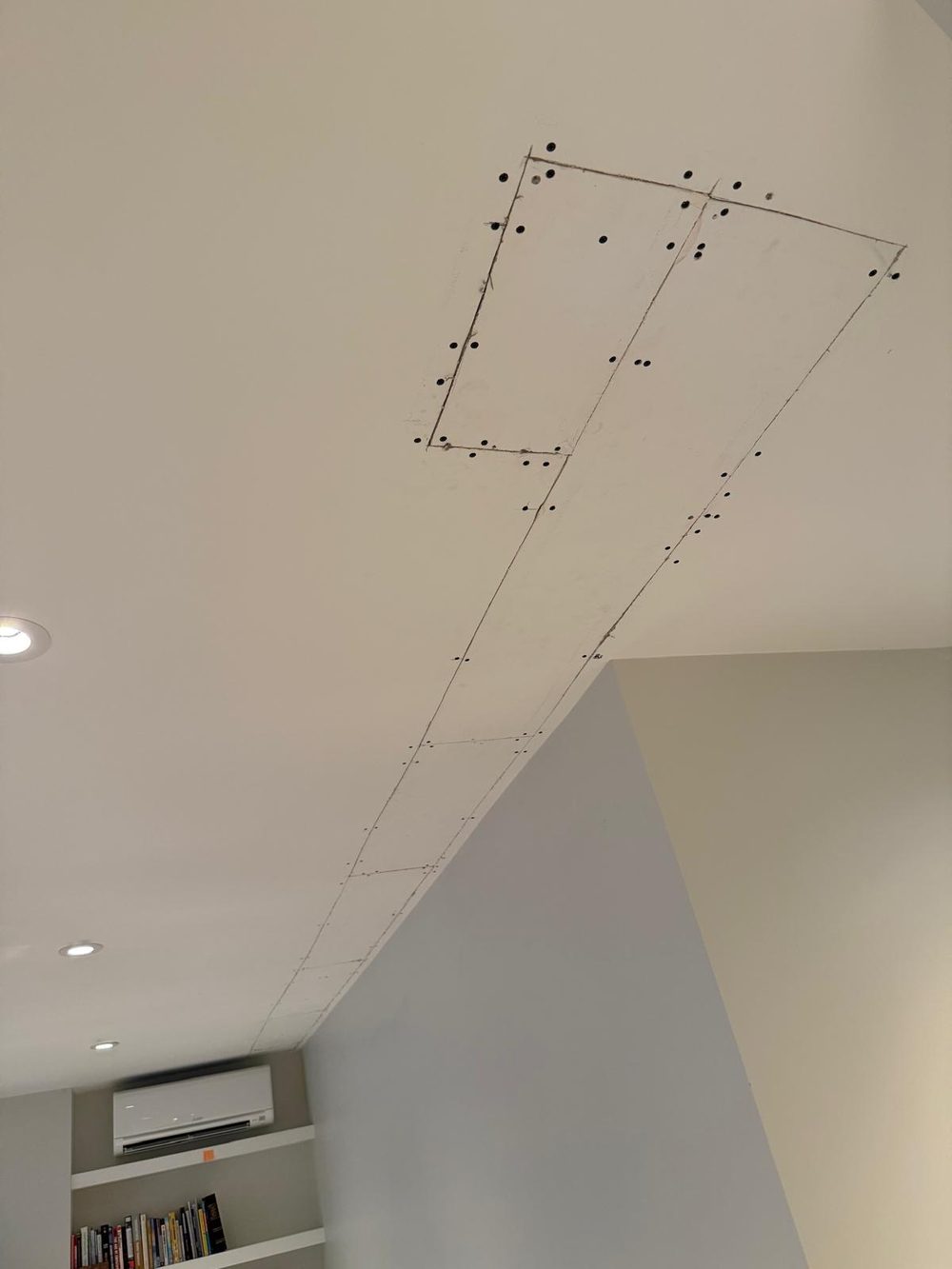 New drywall patch in the ceiling, marked out for finishing
