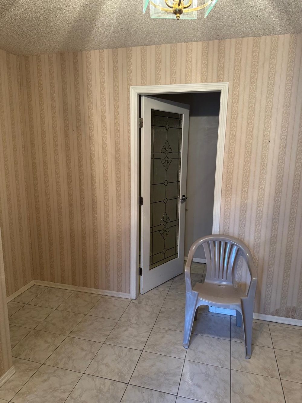 Entry hallway with striped wallpaper before painting